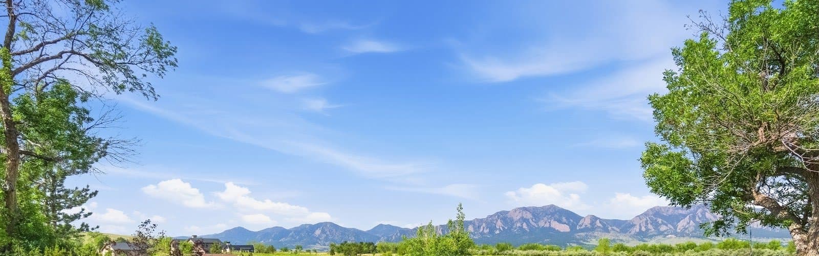 The Flatirons seen across open lawn from a private residence